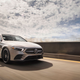 A photo of a silver Mercedes A Class sedan driving along a highway.